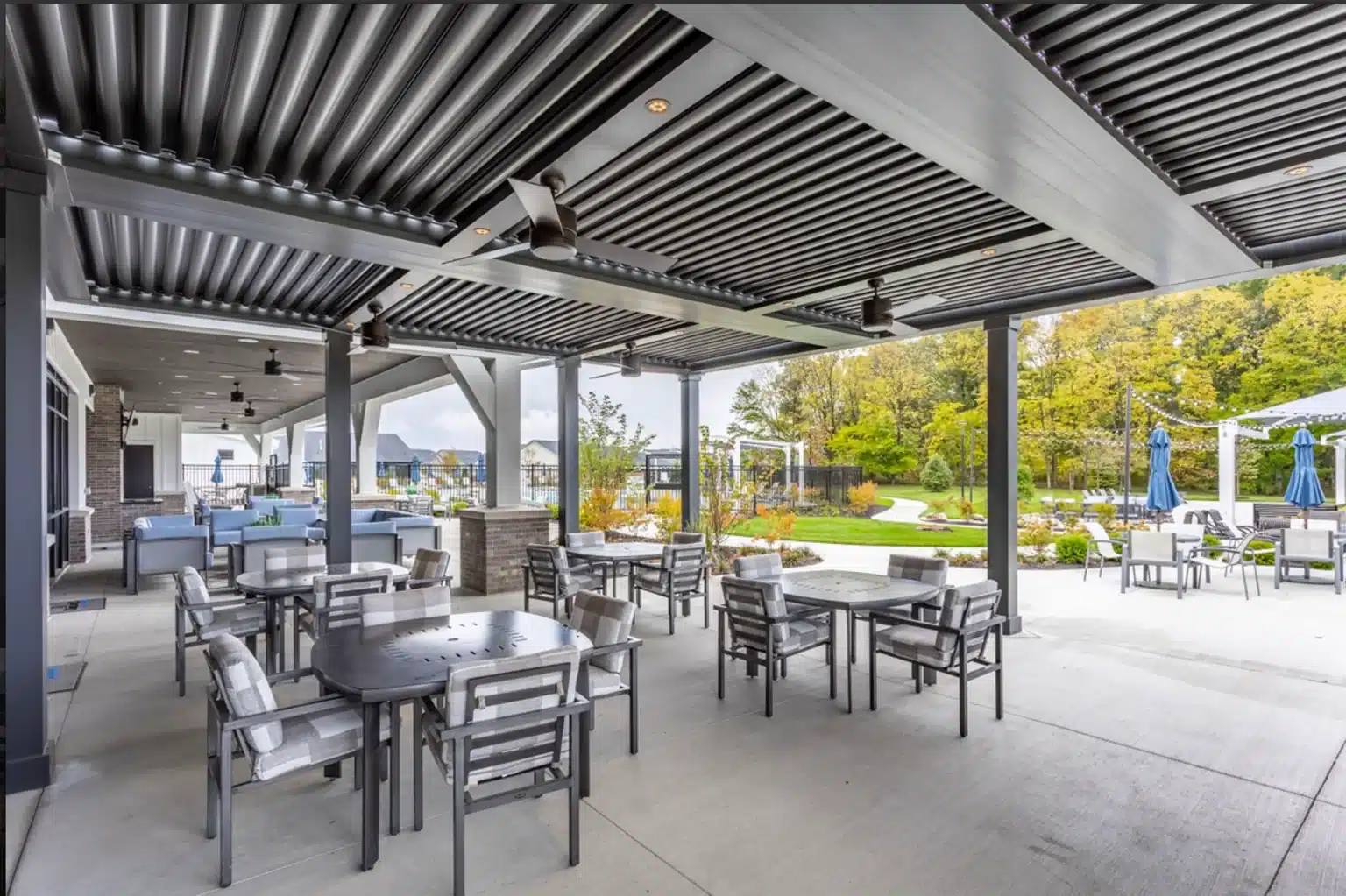 Aluminum pergola shading an outdoor dining and gathering area in a commercial amenity setting