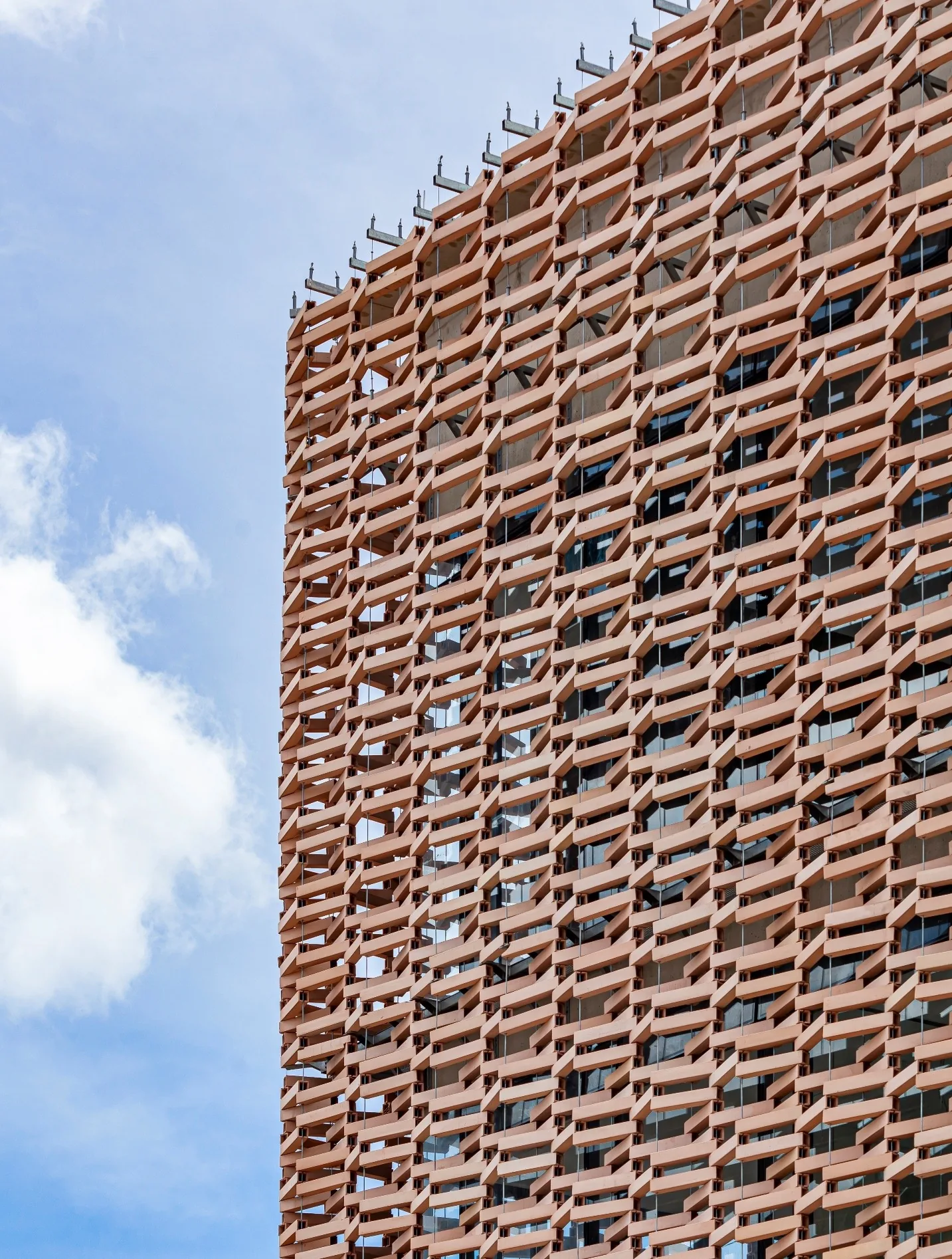 Dimensional terracotta-tone architectural metal screen facade on a commercial building