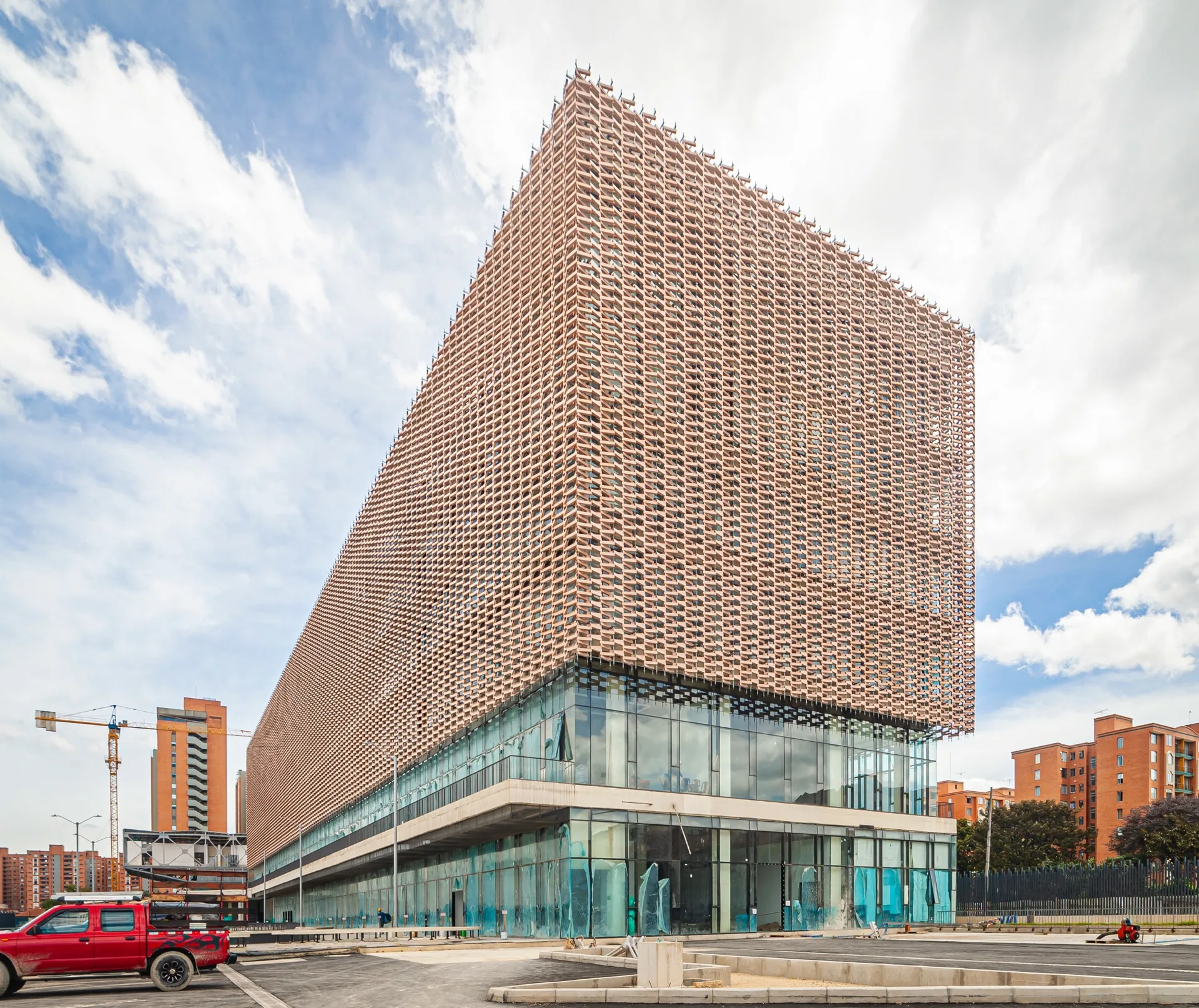 Building exterior wrapped in a three dimensional terracotta tone architectural facade screen