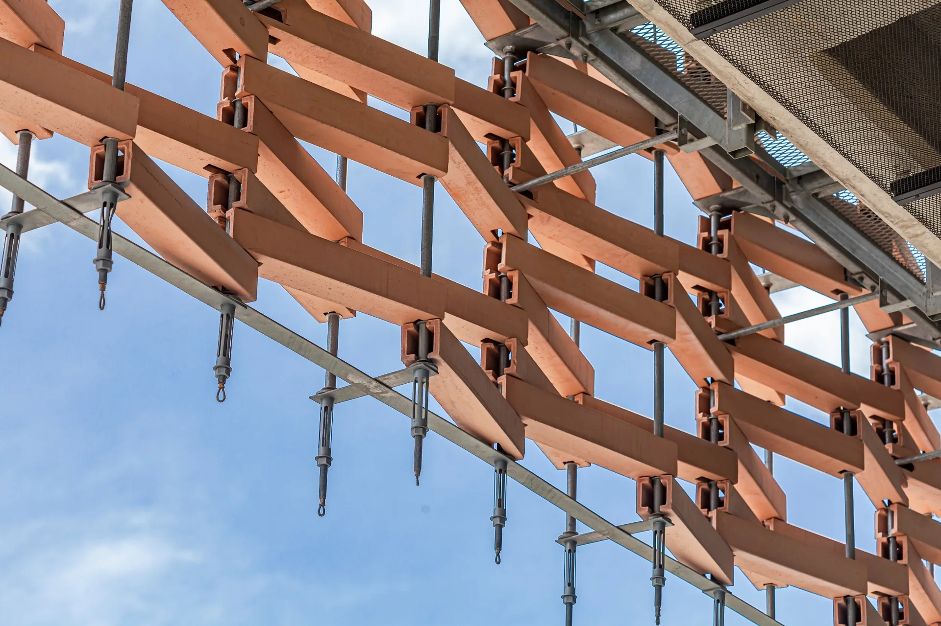 Close view of support framing and attachments for a dimensional architectural facade screen