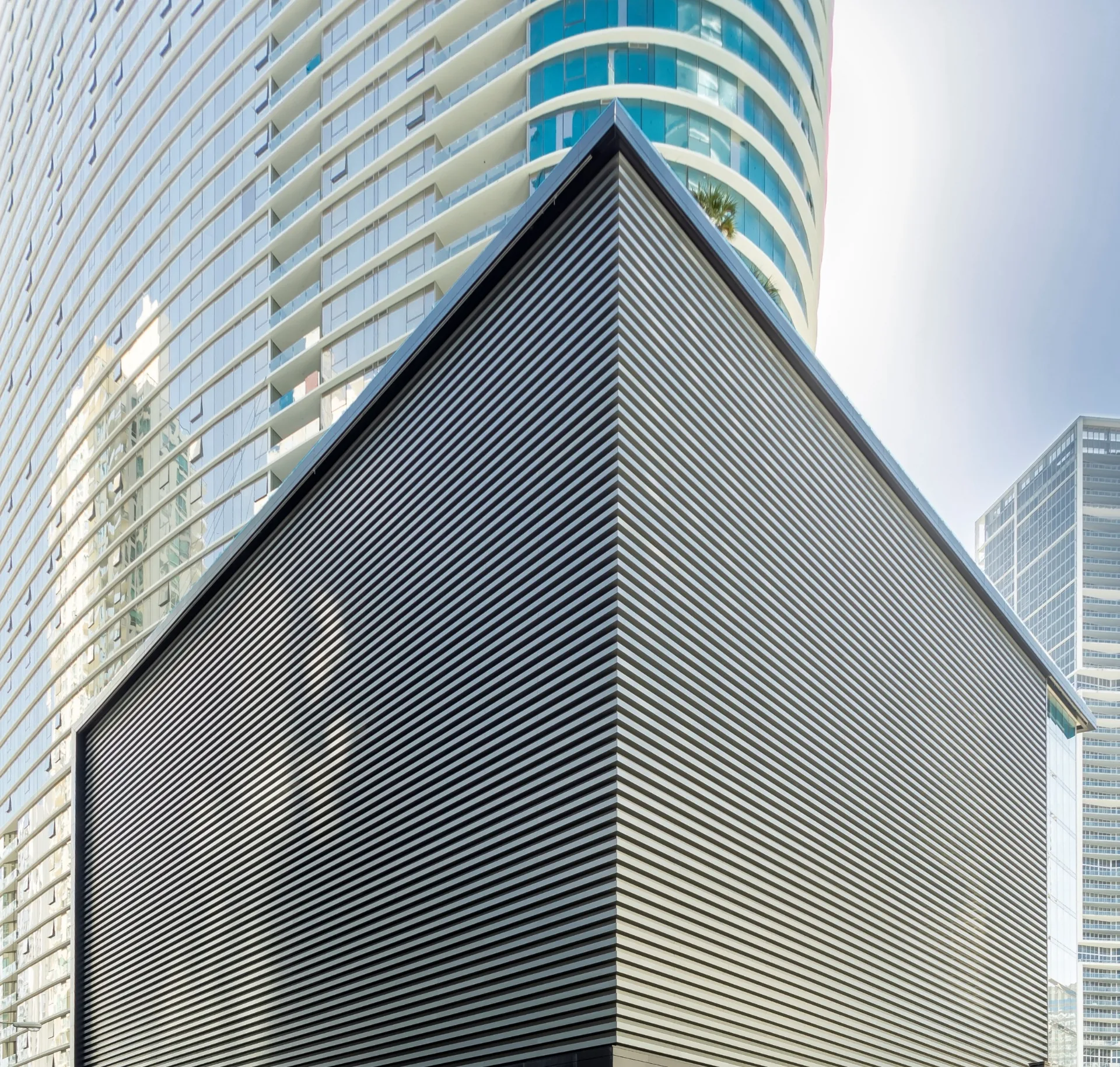 Large exterior architectural facade screen composed of closely spaced horizontal metal louvers