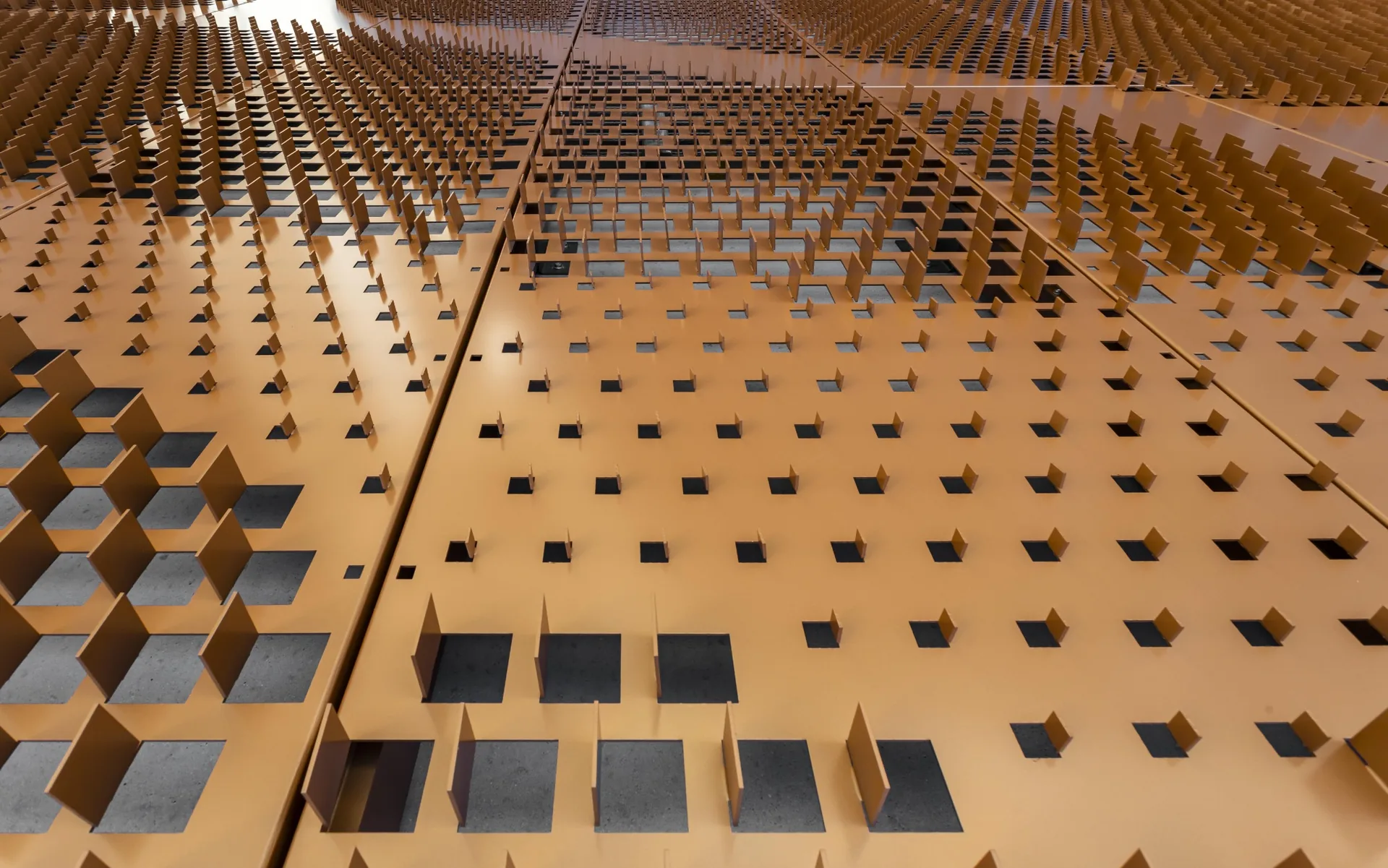 Three dimensional perforated metal facade panel with formed fins in a copper tone finish