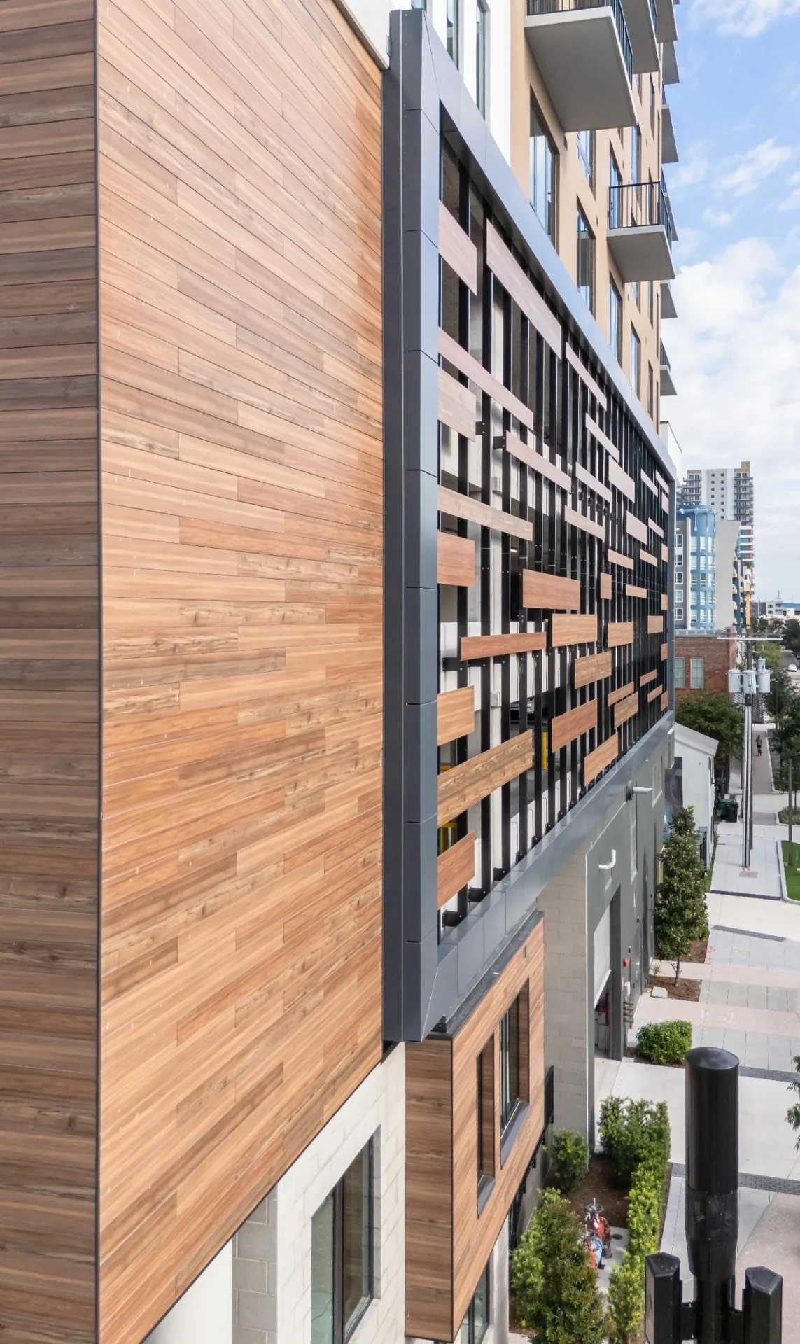 Wood look architectural cladding installed across a multistory building facade